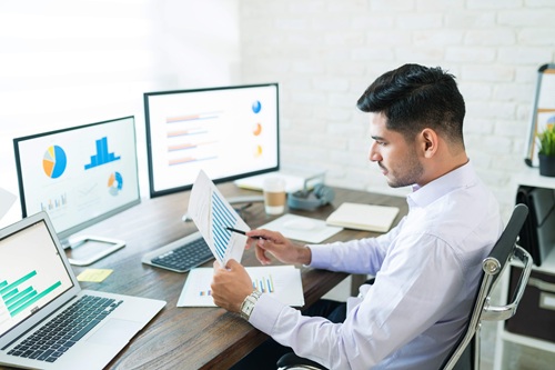 Junior Business Analyst reviewing data charts in a modern office